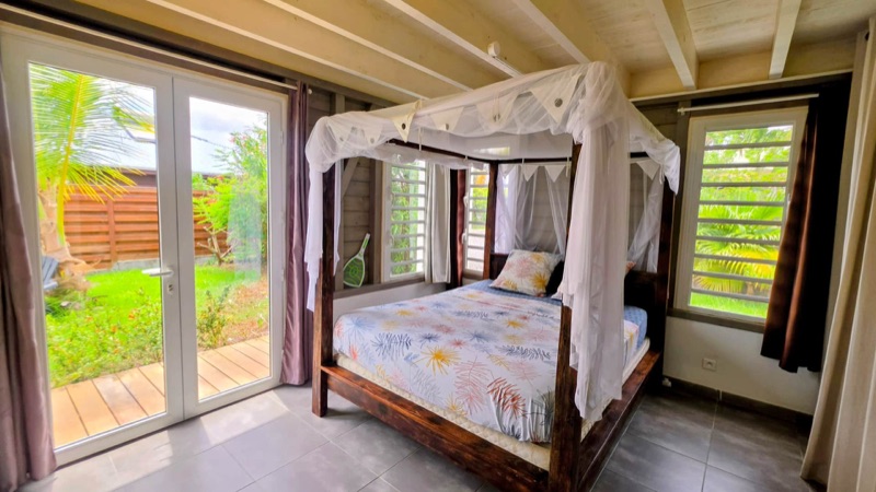 Chambre avec lit à baldaquin ouverte sur le jardin